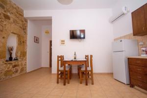 a kitchen with a table and chairs and a refrigerator at Christina Apartments in Kissamos