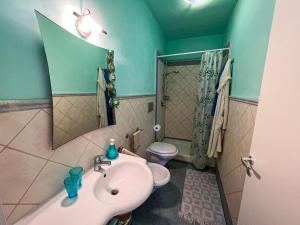 a bathroom with a sink and a toilet and a mirror at Albamare apartment in Marettimo