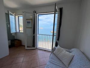 a bedroom with a balcony with a view of the ocean at Albamare apartment in Marettimo