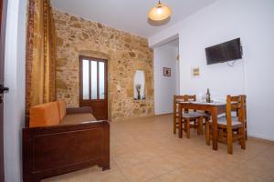 - un salon avec une table et une salle à manger dans l'établissement Christina Apartments, à Kíssamos