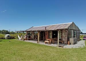 um edifício de tijolos com uma rede num quintal em Caliu Earthship Ecolodge em Colônia do Sacramento