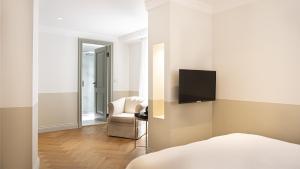 a bedroom with a bed and a chair and a television at Ishak Pasa Palace by Signature Hotels in Istanbul