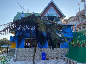 ガントクにあるLamakhang Homestayの青い建物前のヤシの木