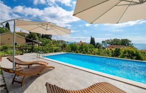 a swimming pool with two chairs and an umbrella at Beautiful Apartment In Ika With Wifi in Ika +20 photos