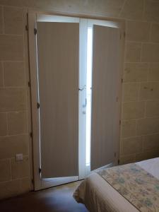 a bedroom with a sliding glass door with a bed at GozoWindmill Apartments in Qala