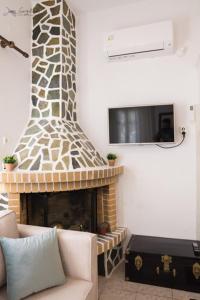 a living room with a fireplace and a tv at Mesa Vrisi in Karpathos