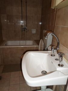 a bathroom with a sink and a toilet and a tub at Tina Hotel in Chania Town
