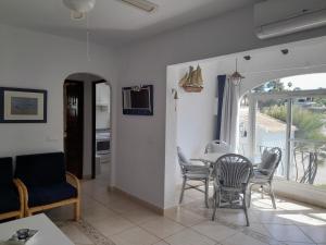 uma sala de jantar e sala de estar com mesa e cadeiras em Villa Adriana v rezidencii Toscamar em Xàbia
