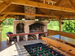 an outdoor entertaining area with a fireplace and a pool table at Kuća za odmor Jopi i Mare in Topusko