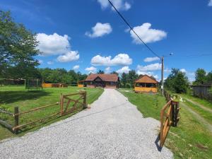 un camino de grava con una valla y una casa en Kuća za odmor Jopi i Mare, en Topusko