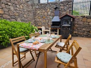 drewniany stół i krzesła z kominkiem na patio w obiekcie Villa MOGAREN w mieście Vega de San Mateo