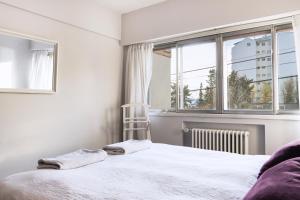 a bedroom with a white bed and a window at Piso villegas in San Carlos de Bariloche
