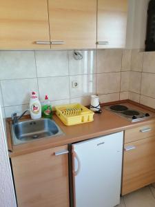 een kleine keuken met een wastafel en een aanrecht bij Apartmani Grgo in Živogošće