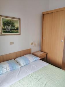 sypialnia z łóżkiem i zdjęciem na ścianie w obiekcie Apartmani Grgo w mieście Živogošće