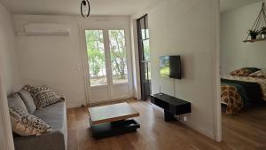 ein Wohnzimmer mit einem Sofa und einem Tisch in der Unterkunft T4 Proche centre et plages Jacuzzi et Parking gratuit in Montpellier