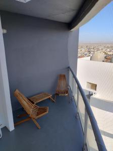 2 chaises assises sur le balcon d'un bâtiment dans l'établissement Vistas de la meseta Patagónica, à Trelew