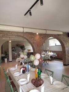 a dining room with white tables and a brick wall at Villa Artisan in Sremski Karlovci