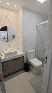 a bathroom with a toilet and a sink and a mirror at ID Vida Urbana Setor Oeste Goiânia 3703A in Goiânia