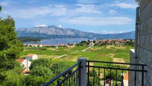 a balcony with a view of a lake and mountains at VILLA Apartments Mate Cebalo in Lumbarda