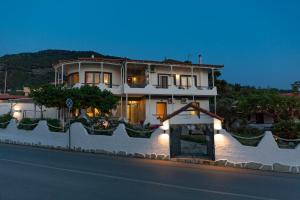 a white house with lights on the side of a street at Karavos Sea View Apartments in Skopelos Town +10 photos