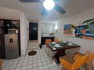 a living room with a table and a kitchen at Villas Cozumel #7 in Cozumel
