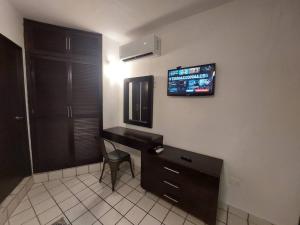 a room with a desk and a television on the wall at Villas Cozumel #7 in Cozumel