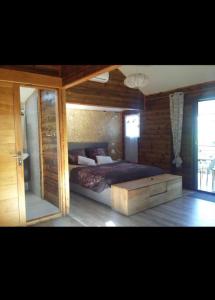 sypialnia z dużym łóżkiem i drewnianą ścianą w obiekcie Chalet L w mieście Saint-Pierre