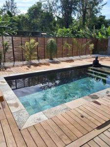 una piscina en un patio trasero con terraza de madera en Chalet L, en Saint-Pierre