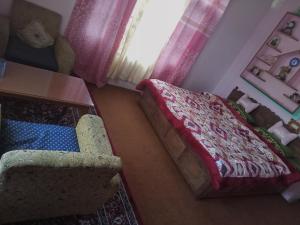 a bedroom with a bed and a chair and a table at Grand Inayat in Srinagar
