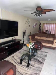 uma sala de estar com um sofá e uma televisão em Comfort Rest em Ocho Rios