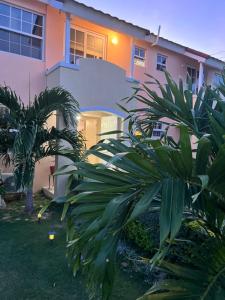uma casa com uma palmeira em frente em Comfort Rest em Ocho Rios