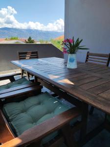 a wooden table with a potted plant on a balcony at Apartments Lanterna Ražanac in Ražanac