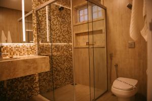 a bathroom with a shower and a toilet at Engenho da Serra Hotel EcoResort in Capitólio