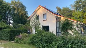 una vieja casa blanca con muchas plantas en Zwols Groen en Zwolle