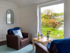 ein Wohnzimmer mit einem Sessel und einem Tisch mit Fenster in der Unterkunft Bay View in Belford