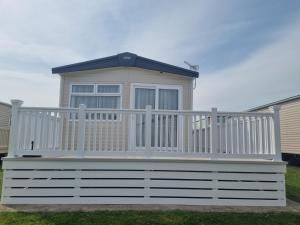 a house with a white railing on a deck at Seaside Jollys in Blue Anchor