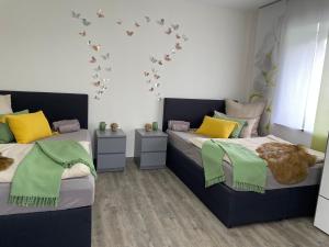 a bedroom with two beds with green and yellow pillows at Ferienwohnung in Hünfeld