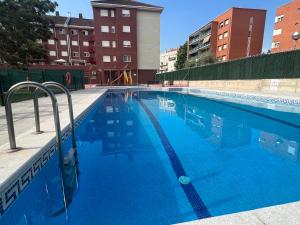 a large swimming pool with blue water at POOL AND CONFORT 3 habitaciones y garaje By apartamentos Logroño in Logroño