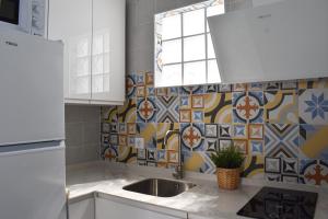 uma cozinha com um lavatório e uma parede de azulejos em Loft La Abuela em Vejer de la Frontera