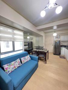 セブシティにある2BR Unit in IT Park Cebu Cityの青いソファとテーブルのあるリビングルーム