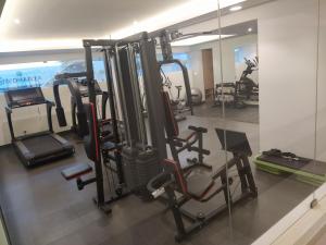 a gym with several tread machines and a mirror at Luxurious Apartment with a pool and gym near Trivandrum railway station in Trivandrum