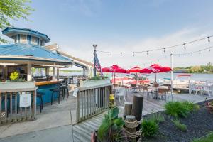 eine Terrasse mit Tischen, Stühlen und roten Sonnenschirmen in der Unterkunft The Blue Heron Inn in LaPorte