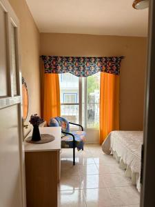 a bedroom with a bed and a window with orange curtains at Yalcinkayalar Aparthotel in Datca
