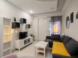 a living room with a black couch and a tv at The Cozy Nest in Rhodes town in Rhodes Town