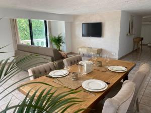 a dining room with a table and a couch at CHARMANT 2 PIECES DANS VILLA INDIVIDUELLE TERRASSES JARDIN in Carros