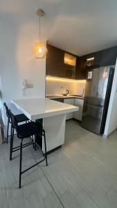eine Küche mit einem weißen Tisch und einem Kühlschrank in der Unterkunft Departamento entero, cerca Plaza Egaña, Estacionamiento gratis in Santiago