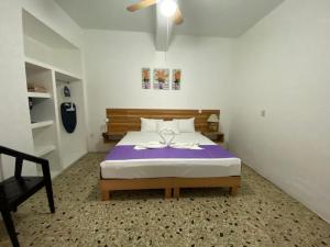 een slaapkamer met een bed met een paarse deken bij Casa Gubidxa in Oaxaca City