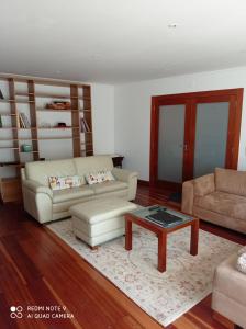 uma sala de estar com dois sofás e uma mesa de centro em Moradia, 4 quartos, a 200 metros da praia em Perafita