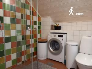 a bathroom with a toilet and a washing machine at Mornamaa puumaja Pesä 2 
