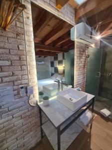 baño con lavabo en una pared de ladrillo en Loft 41 by Casa Matia, en San Miguel de Allende